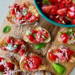 Cherry Tomato Bruschetta Appetizer on Platter with Sweet Cherry Tomatoes, Fresh Basil Ribbons, and a Garlic, Balsamic Vinegar, and Olive Oil Marinade on a Toasted Baguette.