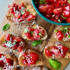 Cherry Tomato Bruschetta Appetizer on Platter with Sweet Cherry Tomatoes, Fresh Basil Ribbons, and a Garlic, Balsamic Vinegar, and Olive Oil Marinade on a Toasted Baguette.